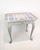 Flisebordet i 
rokokostil, 
gråmalet og 
dateret til 
1780, er et 
charmerende 
eksempel på 
klassisk ...