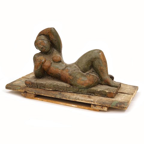 Skulptur in Form von einer ruhenden Frau aus 
glasiertem Steinzeug. Masse inkl. Podest H: 35cm. 
L: 65cm. B: 31cm