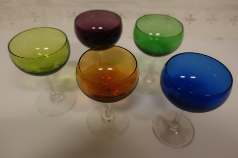 Smukke farvede glas 
Farvede kummer med klar glasfod
Det præcise glasværk for produktionen har ikke kunnet identificeres med 
sikkerhed
Grøn, blå, orange, mørk rød/aubergine og gulgrøn 
H: ca. 10cm