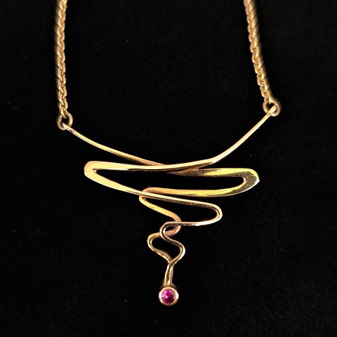 A necklace set with a ruby, mounted in 14k gold