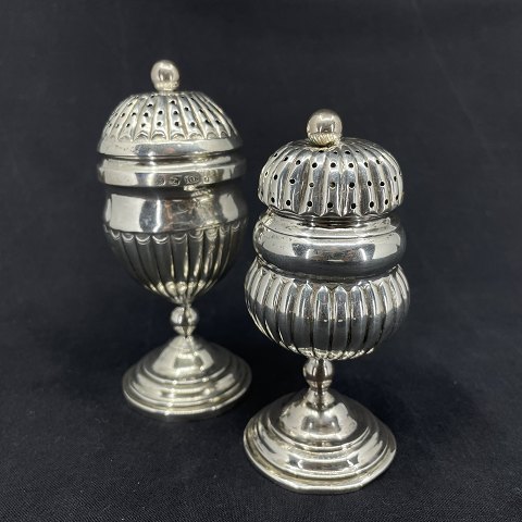 A pair of silver pepper shakers