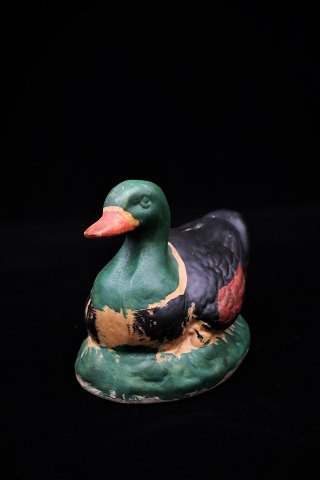 Old Swedish piggy bank in the form of duck in painted ceramic.
H:10,5cm. L:14cm.
