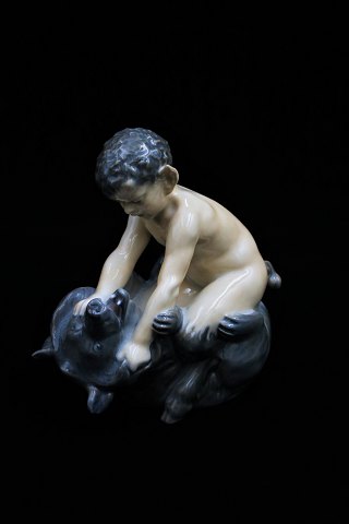 Royal Copenhagen porcelain figurine of Pan figurine sitting on bear. 
DJ#648. 2.sort. Height: 15,5cm.
