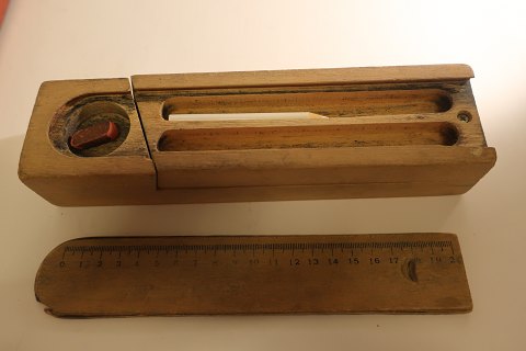Pennalhus/pennehus af træ fra gammel tid
Med låg lavet som centimetermål og 2 "lag" til at have skriveredskaber og 
viskelæder
