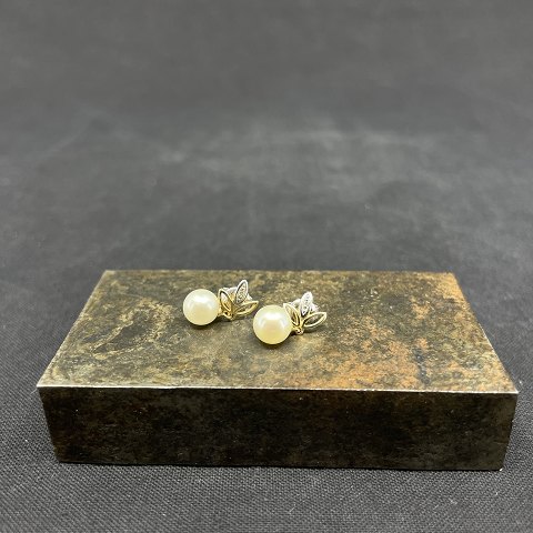 A pair of gold ear studs with pearls