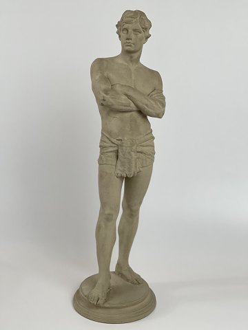 Antik terracotta-figur af stående mand med lændeklæde. Figuren er stemplet L. P. Jørgensen København, eneret. Cirka 1890
