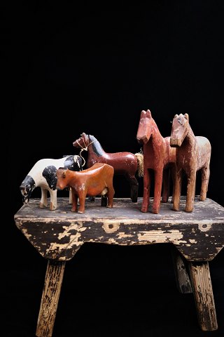 Old carved horses and cows in wood with old paint and patina...
