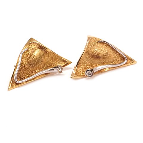Ein paar Ohrenclips aus 14kt Gold jeder mit einem 
Brillanten von etwa 0,1ct. Grösse: 18x34mm