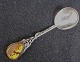 Marmelade ske i 
sølv, o. 1950, 
dekoreret med 
slomster og 
ranker og 
ravklump. 
Stemplet 925 S. 
L.: ...