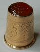 Fingerbøl i 14 
karat guld med 
rød sten på 
toppen. 
Dekoreret rundt 
om 
fingerbøllet. 
Stemplet 585 
...