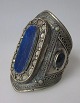 Afgansk arm smykke, 20. årh. Forsølvet metal med dekorationer og lapis lazuli. H.: 10 cm. Dia.: ...