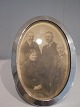 J.Holm oval 
ramme i 
tretårnet sølv 
med slebent 
glas  fra 1919. 
Mål: 16 x 11 
cm.