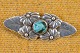 Broche med 
blomster i sølv 
og kerne af 
tyrkis keramik. 
Skønvirke 
inspireret. 
Stemplet ARK 
830S. ...
