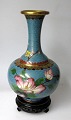 Cloissonne 
vase, Kina, 20. 
årh. Polykrom 
dekoration på 
lyseblå font 
med fugl i 
blomstrende ...
