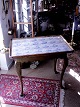 Rococo 
flisebord af 
malet træ 
svungne ben 
udskåret med 
blade, udtræk 
til lysestager. 
Plade med ...