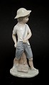 Nao, Spanien, 
Dreng med 
slangebøsse. 
Højde 21,5 cm. 
Afslag på 
undersiden af 
hatten. Pris: 
400 kr.