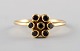 Carré ring in 18 kt. gold in the form of a flower. Adorned with 7 black 
diamonds.