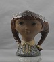Figur i keramik 
med motiv af 
pige med 
fletninger og 
blomsterkrans
Design af 
Lladro
Keramik, ...