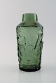 Finsk 
glaskunstner. 
Vase i grønt 
mundblæst 
kunstglas. 
Abstrakt motiv. 
1970'erne. 
Måler: 22 x 
...