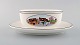 Villeroy & Boch Naif gravy boat on stand in porcelain decorated with naivist 
village motif.