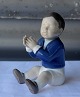 Figur i 
porcelæn med 
motiv af Dreng, 
der klapper i 
hænderne. Nr. 
2337 
Design af Bing 
og ...