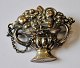Silver brooch, 
Bowl of fruits 
and putto with 
cross, 19th 
century. With 
chains. 
Stamped: HH and 
...