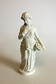 Bing & Grøndahl 
Biscuit figur 
af stående 
kvinde med 
blomsterkurv. 
Måler 31 cm. 
Afslag på 
soklen