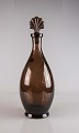 Karaffel i 
lillabrunt glas 
med glasprop i 
dansk design
Karaffelens 
prop er 
udformet som en 
...
