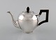 Bonebakker & Zoon, Amsterdam. Silver teapot with handle and wooden knob. Beaded 
border in top and bottom. Knob shaped like spruce cone. Mid-19th century.
