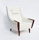 Lænestolen med 
høj ryg, smukt 
polstret i 
hvidt stof og 
elegant 
hvilende på 
palisanderben, 
...