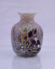 Multifarvet 
glasvase. Vasen 
er med indlagt 
og trukket 
forskellige 
farver glas. 
Vasen er 
4-kantet ...