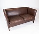 To personers sofa polstret med mørke brunt læder af dansk design fremstillet af Stouby ...