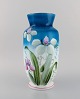 Antik vase i 
mundblæst 
opalineglas med 
håndmalede 
blomster og 
bladværk på blå 
baggrund. Ca. 
...