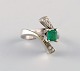 Georg Jensen ring in 18 carat white gold adorned with emerald and numerous 
brilliant-cut diamonds. Dated 1945-51.
