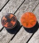 2 danske, lave 
tinkrukker, låg 
beklædt med 
keramik kakkel.
Stempel: 
Handmade 
Denmark - H+F
H ...