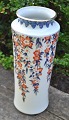 Japansk vase i 
porcelæn. 20. 
årh. Dekoreret 
i imari teknik 
med blomster 
ranker og 
forgyldninger. 
...