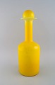 Otto Brauer for 
Holmegaard. 
Stor 
vase/flaske i 
gult kunstglas 
med gul kugle. 
1960'erne. 
Måler: ...
