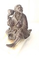 Japansk figur af bronze af en siddende klog mand med skål. Figuren er skruet (nyere skrue)  på  ...
