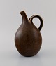 Eva Stæhr-Nielsen for Saxbo. Pitcher in glazed stoneware. Beautiful glaze in 
brown shades. Model number 64. Mid 20th century.
