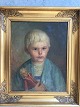 Christian Rhode 
(født 1887):
Portræt af 
lille pige med 
Dagmarkors og 
dukke 1952.
Olie på ...
