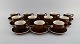 Stig Lindberg for Gustavsberg. Twelve Coq coffee cups with saucers in glazed 
stoneware. Beautiful glaze in brown shades. Swedish design, 1960s.
