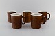 Stig Lindberg for Gustavsberg. Five large Coq mugs in glazed stoneware. 
Beautiful glaze in brown shades. Swedish design, 1960s.
