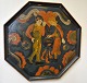 Norsk octagon 
malet bakke, 
20. årh. Motiv 
af en mand og 
kvinde, der 
står ved en 
gryde og rører 
...