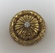 Guld broche med diamant i 18K guld (750). Diamant ca. 0,20ct. Diameter 25 mm