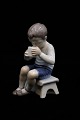 Bing & Grøndahl 
porcelænsfigur 
af lille dreng 
der drikker 
mælk.
H:13cm. 
Dekorationsnummer: 
...