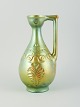 Zsolnay, 
Ungran. Stor 
keramik-kande 
med 
eosin-glasur 
modelleret med 
bladværk.
Midt ...