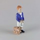 Figur i 
porcelæn med 
motiv af en 
dreng iklædt 
skoleuniform og 
med skoletaske 
no 685
Producent ...