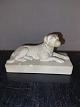 Figur af liggende hund på base udført I terrakotta. Fremstillet omkring 1900. Flere små skår ...