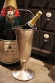 Gammel fransk champagnekøler på fod i metal med hank og en fin patina. Højde: 49cm. Dia.: 17,5cm.