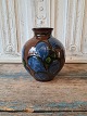 Kähler vase 
kohorns 
dekoreret med 
bladværk i 
brun, blå og 
grønne nuancer 
Signeret HAK
Højde ...